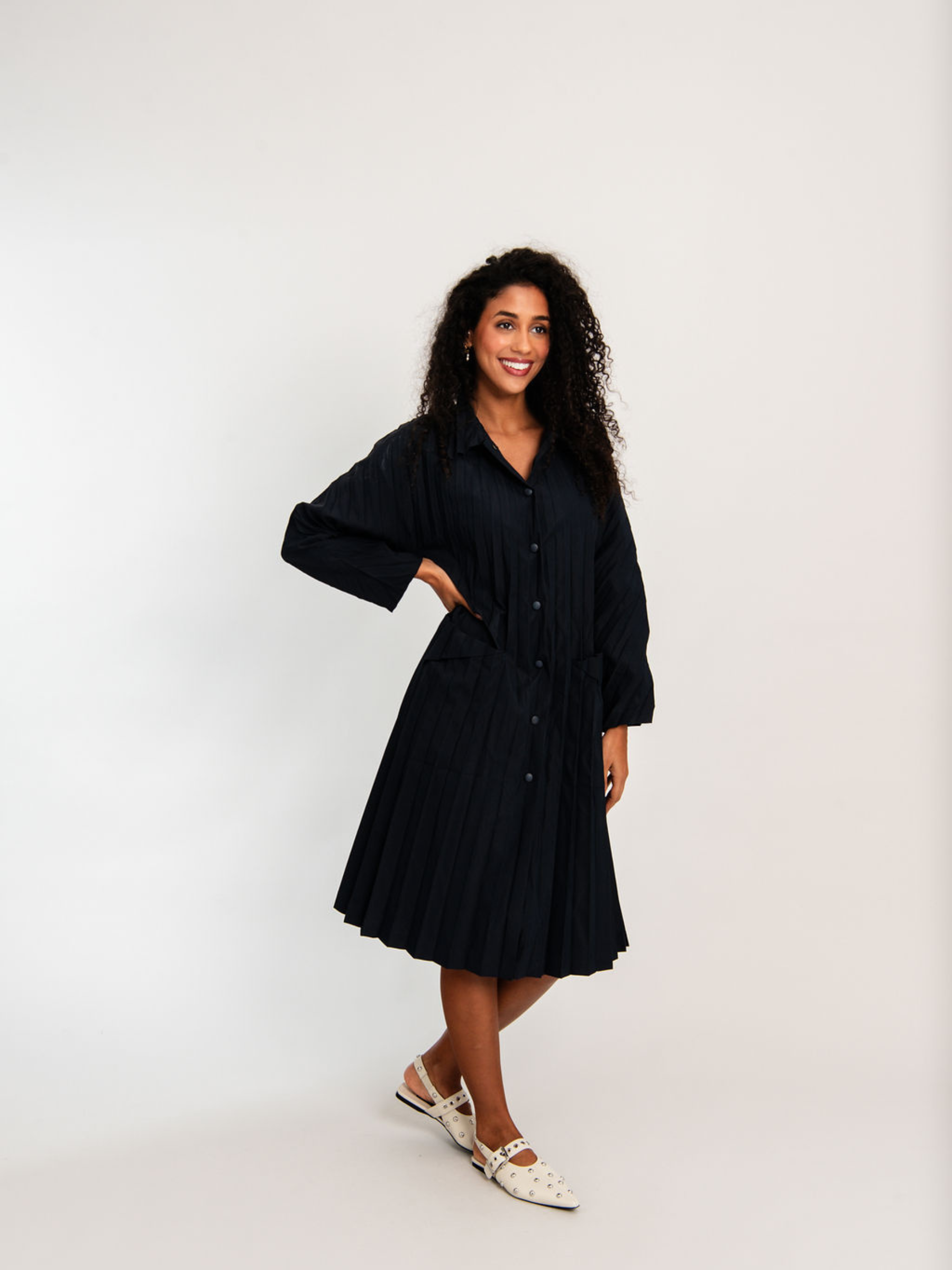 Woman wearing a black dress against a white background